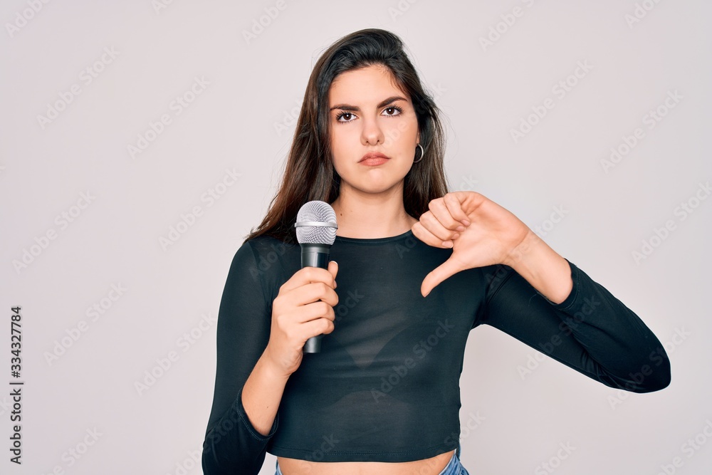 Young beautiful singer performer girl singing using music microphone ...
