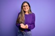 © Krakenimages.com - Young beautiful smart woman wearing glasses over purple isolated background Smiling with hands palms together receiving or giving gesture. Hold and protection