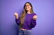 © Krakenimages.com - Young beautiful smart woman wearing glasses over purple isolated background very happy and excited doing winner gesture with arms raised, smiling and screaming for success. Celebration concept.