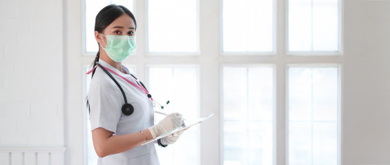 Wall Mural - Side view of happy female doctor writing patient chart on digital tablet