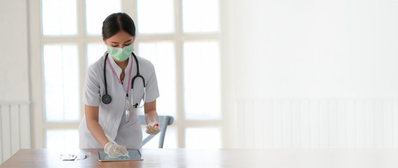 Wall Mural - Cropped shot of female doctor analysing blood tests on digital tablet in examination room