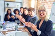 © Krakenimages.com - Group of business workers smiling happy and confident. Working together with smile on face looking at the camera applauding at the office