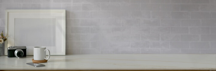 Cropped shot of simple workspace with copy space, camera, mock-up frame and coffee cup