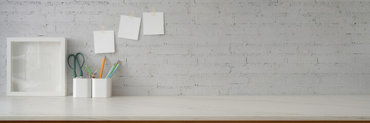 Cropped shot of minimal workspace with mock-up frame, supplies, stationery and copy space