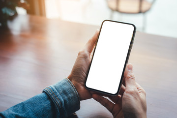 Mockup image blank white screen cell phone.woman hand holding texting using mobile on desk at coffee shop.background empty space for advertise text.people contact marketing business,technology