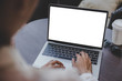 © panitan - mockup image blank screen computer with white background for advertising text,hand woman using laptop contact business search information on desk at coffee shop.marketing and creative design