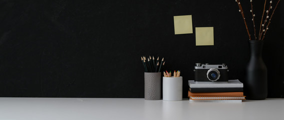 Cropped shot of dark modern concept workspace with copy space, camera, stationery and decorations