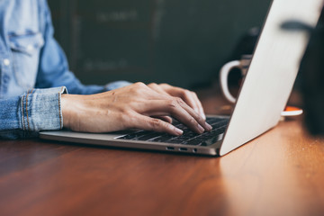 using computer.hand typing message on keyboard laptop online chatting search information form internet while working on laptop concept for technology device contact communication business people