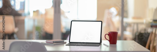 Fotografía Cropped shot of office desk with blank screen laptop, notebooks and coffee cup i