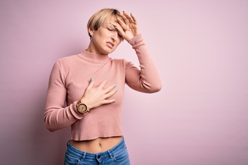 Wall Mural - Young blonde woman with short hair wearing casual turtleneck sweater over pink background Touching forehead for illness and fever, flu and cold, virus sick