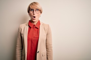 Sticker - Young blonde business woman with short hair wearing glasses and elegant jacket afraid and shocked with surprise expression, fear and excited face.