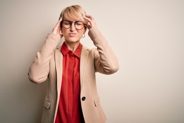 Wall Mural - Young blonde business woman with short hair wearing glasses and elegant jacket suffering from headache desperate and stressed because pain and migraine. Hands on head.