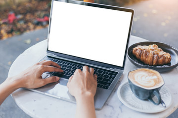 computer mockup image blank screen with white background for advertising text,hand woman using laptop contact business search information on desk at coffee shop.marketing and creative design