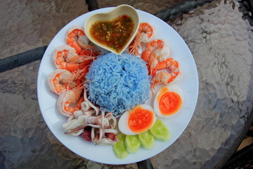 Seafood Rice with chrimp squid and egg on the white disc.