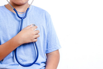 The boy wears a medical stethoscope to listen to the sound of his own heart. Concept of child treatment. White background