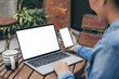 © panitan - computer,cell phone mockup image blank screen with white background for advertising text,hand woman using laptop texting mobile contact business search information on desk in cafe.marketing,design