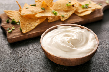 Tasty sour cream and potato chips on table