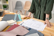 © pressmaster - Young creative female designer in casualwear working with house sketch by table