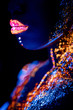 © Roman - beautiful young african woman with fluorescnet luminescence prints on skin, glowing in UV light. isolated space. fluorescent make-up, body art