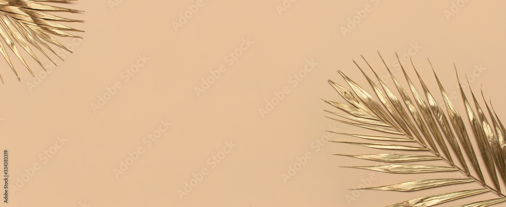 Gold colored tropical palm leaves on beige background flat lay top view copy space. Creative summer background with tropical leaves. Golden background, minimal nature concept - obrazy, fototapety, plakaty 