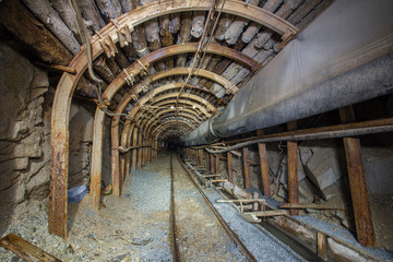 Underground gold mine tunnel with steel arch and rails