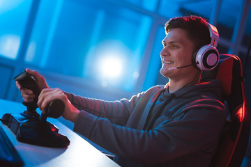 the gamer sitting at the table and playing video games in the neon room