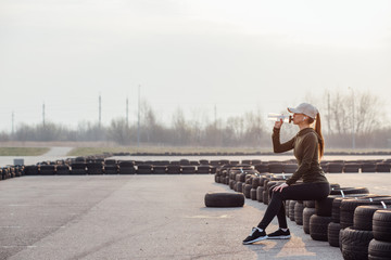 Wall Mural - beautiful girl at morning workout drinks water from a bottle