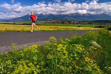 Wall Mural - Athlete train in morning summer landscape under beautiful mountains. High Tatras, Slovakia