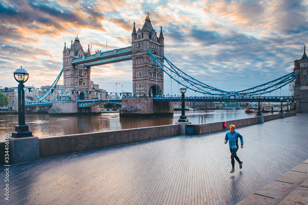 Obraz na płótnie Alone runner in empty streets of london in Coronavirus, Covid-19 quarantine time. Tower Bridge in background w salonie