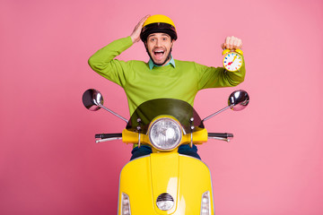 Poster - Portrait of his he nice attractive lucky glad cheerful cheery guy riding moped holding in hand clock good healthy regime isolated over pink pastel color background