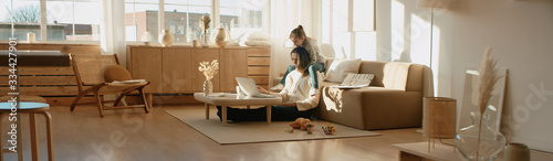 Fotomural Mother working from home, having a phone call, while her daughter distracts her