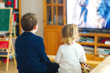 Cute Little Toddler Girl And School Kid Boy Watching Animal Movie Or Movie On Tv. Happy Healthy Children, Siblings During Coronavirus Quarantine Staying At Home. Brother And Sister Together. No Face