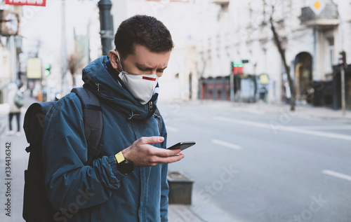 Cuadros en Lienzo masked man on the street with a smartphone