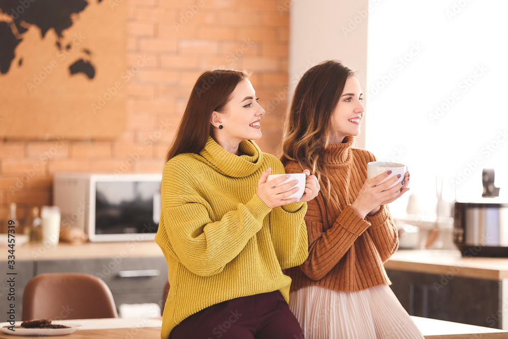 Young women drinking tea in kitchen