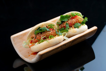 Bao. Steamed rice rolls with shrimp and herbs.  On a black background. Vegetarian dish.