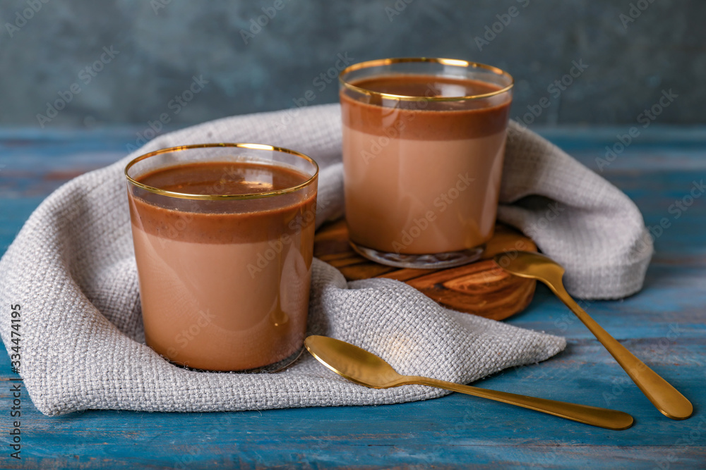 Glasses of hot chocolate on wooden background