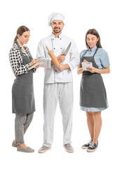 Wall Mural - Male chef with participants of cooking classes on white background