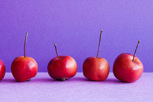 Mini Apples Fruits On A Purple Background. Still Life Dessert Malus Pumilla Composition