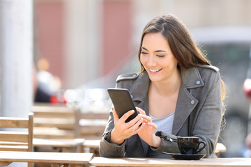 Poster - Happy woman checking phone in a coffee shop