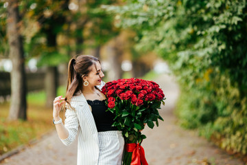 Valentines day. Woman holding bouquet of red roses. Beautiful girl received romantic present.