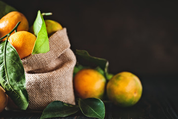 Wall Mural - Tangerines with leaves on an old fashioned country table. Selective focus. Horizontal.