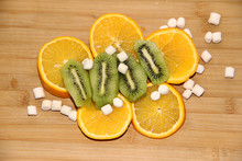 Kiwi And Orange Slices And Marshmallows On A Chopping Board