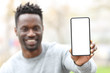 © PheelingsMedia - Happy black man showing phone screen mockup
