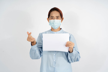 A  Middle age asian woman wearing a medical face mask, holding an empty card, blank space template. And show two fingers mini heart symbol love to fight and strong encourage health care from Covid 19.