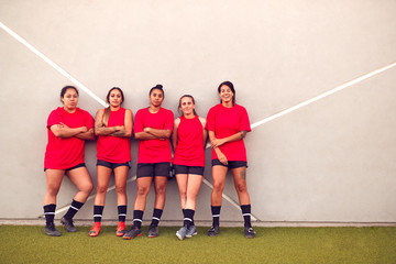 Wall Mural - Graphic Shot Of Womens Football Team Leaning Against Wall Whilst Training For Soccer Match