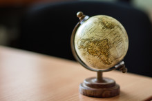 Single Brown Vintage Globe On A Wooden Stand, Copy Space, Blurred Background