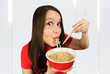 Young girl in a red t shirt eats chinese noodles with chopsticks