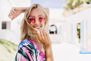 ecstatic girl wears pink sunglasses expressing happiness in summer day. outdoor photo of wonderful t