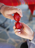 Fototapeta Londyn - hands holding cracked red Easter eggs - Orthodox greek tradition of cracking eggs - symbolizes Christ resurrection
