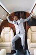 © LIGHTFIELD STUDIOS - scared african american businessman standing and having panic attack during flight on private plane